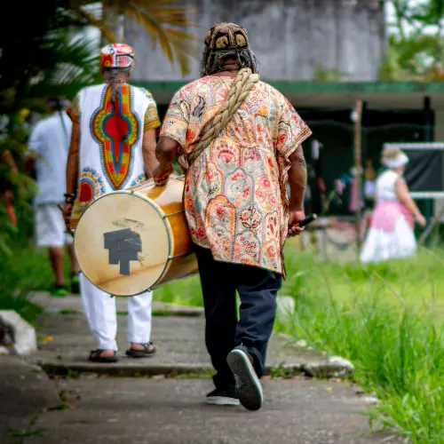 Músicos do Clube de Bambas, caminhando com instrumentos no alto do Monte Serrat, em Santos.
